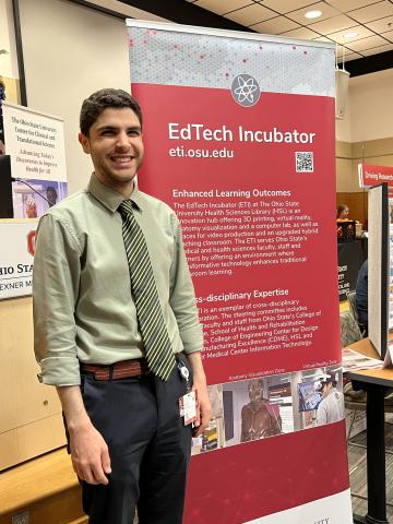 Dr. Nassani stands in front of ETI banner at the 2024 FAME Resource Event
