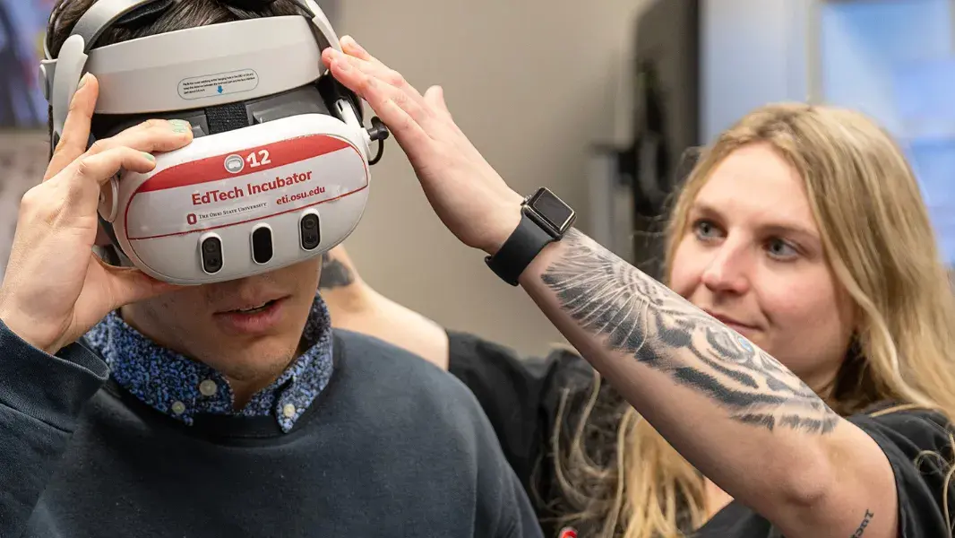 Jenna Kuczek assisting another student using EdTech Incubator's VR headset.