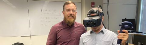 two people with one wearing VR equipment