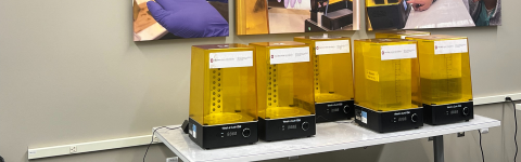 Five 3D resign printers with yellow hoods