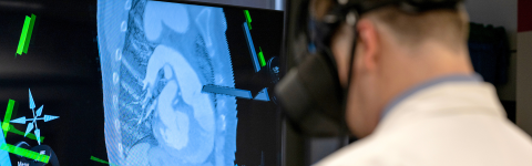 Man in white lab coat with VR headset and CT scan on background screen