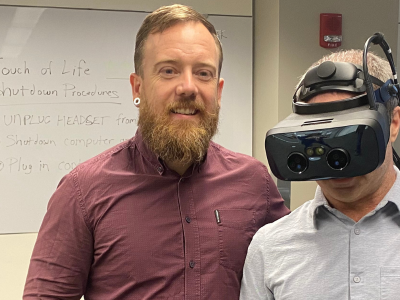 two people with one wearing VR equipment