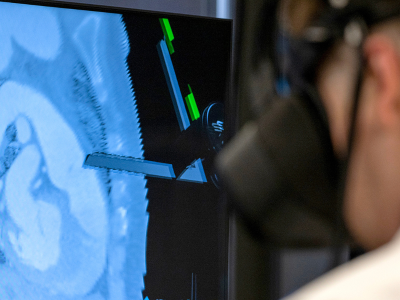 Man in white lab coat with VR headset and CT scan on background screen